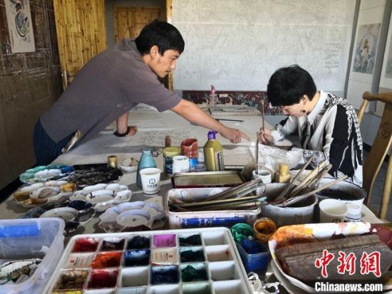 圖為2020年8月下旬，敦煌“80后”畫(huà)家張杰龍(左)在為云南麗江“學(xué)生”莫北講解敦煌壁畫(huà)的繪畫(huà)技巧?！●T志軍 攝