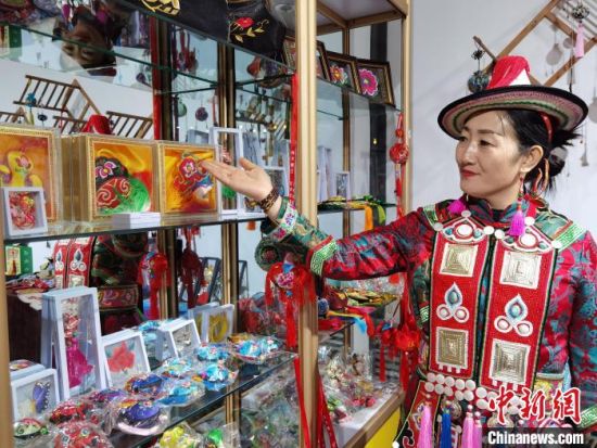 圖為身著民族服飾的隴原巧手展示手工藝品。(資料圖) 徐雪 攝