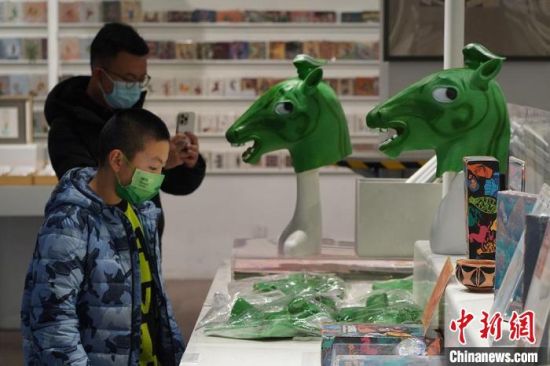 圖為“神馬來了”銅奔馬頭套吸引參觀者駐足?！【琶赖┰?攝