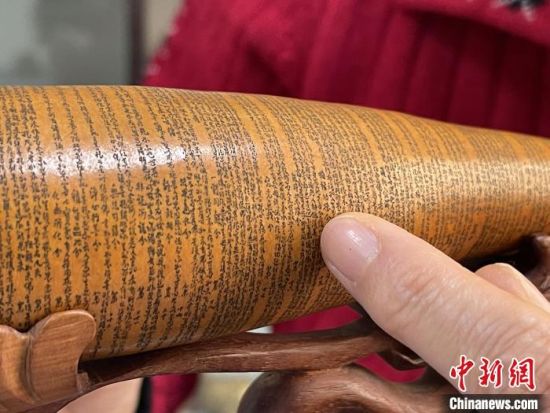 圖為長約二十公分的長條葫蘆雕刻佛教經(jīng)文作品。　張婧 攝