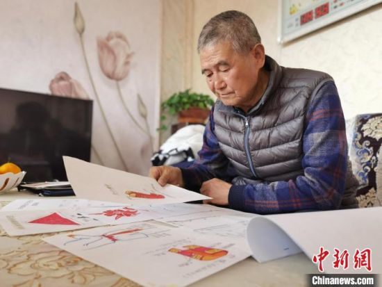 圖為陸鵬飛向記者展示多年帶隊(duì)的手寫(xiě)筆記?！堟?攝