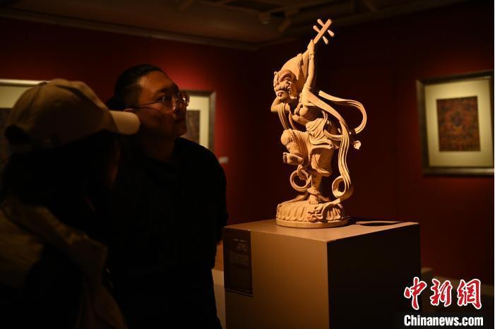 圖為季茂杰向參觀者介紹自己創(chuàng)作敦煌木雕的過程。李亞龍 攝</p>
<p>