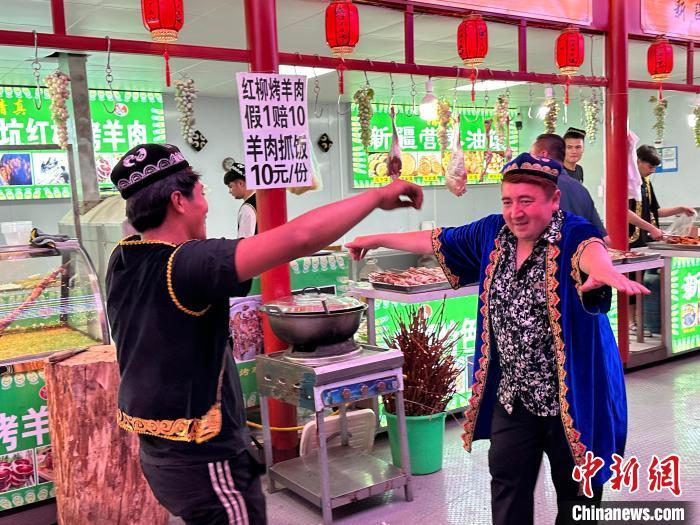 圖為餐飲經(jīng)營者在“西涼不夜城”跳起舞蹈引客?！〈魑牟?攝</p><p>