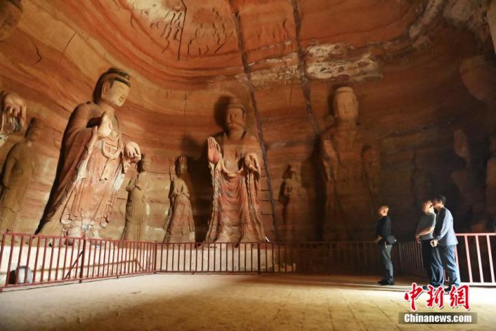 7月15日，游人參觀甘肅省平?jīng)鍪袥艽h百里石窟長(zhǎng)廊中的南石窟寺1號(hào)窟。百里石窟長(zhǎng)廊位于涇川縣境內(nèi)，由512個(gè)石窟、5眼窟中石井組成，現(xiàn)存王母宮石窟、鳳凰山石窟、南石窟寺、丈八寺石窟、羅漢洞石窟、太山寺石窟等規(guī)模較大的石窟群，還有數(shù)量眾多的小石窟群。南石窟寺開(kāi)鑿于北魏永平三年，其中1號(hào)窟屬于大型七佛窟，七佛高達(dá)6米。中新社記者 李亞龍 攝