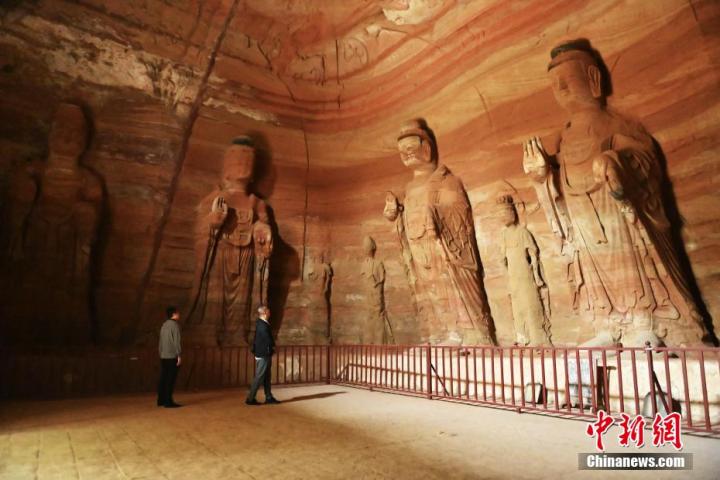 7月15日，游人參觀甘肅省平?jīng)鍪袥艽h百里石窟長(zhǎng)廊中的南石窟寺1號(hào)窟。百里石窟長(zhǎng)廊位于涇川縣境內(nèi)，由512個(gè)石窟、5眼窟中石井組成，現(xiàn)存王母宮石窟、鳳凰山石窟、南石窟寺、丈八寺石窟、羅漢洞石窟、太山寺石窟等規(guī)模較大的石窟群，還有數(shù)量眾多的小石窟群。南石窟寺開(kāi)鑿于北魏永平三年，其中1號(hào)窟屬于大型七佛窟，七佛高達(dá)6米。中新社記者 李亞龍 攝